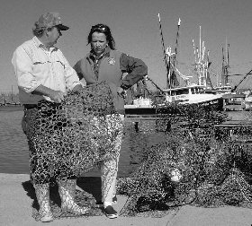 view of two volunteers evaluating 
	abandoned crab trap