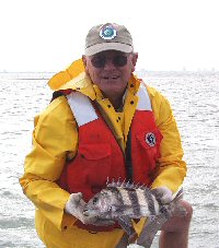 biologist with sheepshead in all weather 
	gear