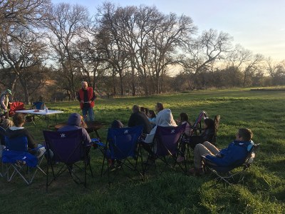 Bill Lindemann gives a presentatino on owls to a group of park visitors gathered around a campfire.