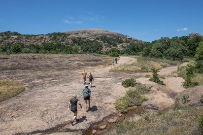 People Hiking Enchanted Rock Summit Trail