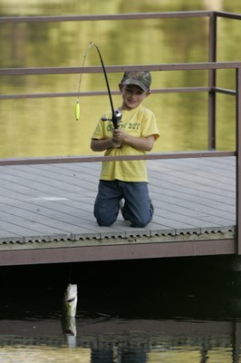 Boy on a pier holding a fishing pole