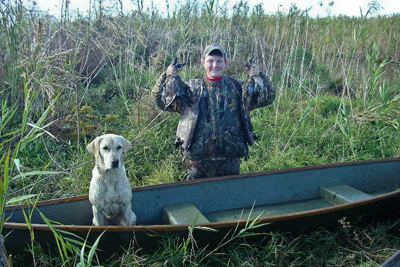 Young hunter with harvested ducks and dog