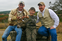 Young hunter and two adults with harvested deer