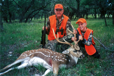 Adult and youth hunter with axis deer