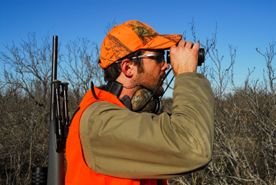 hunter peering through binoculars