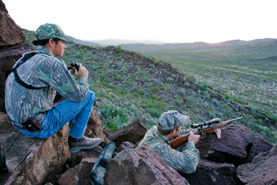 2 hunters posting on a hill