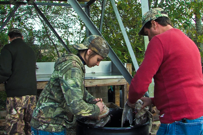 hunters picking feathers from ducks