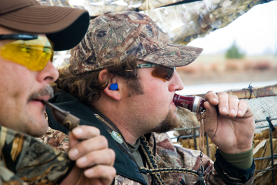 Hunters in blind using duck calls