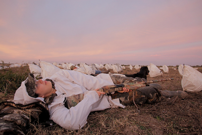 Goose hunter lying in rag spread