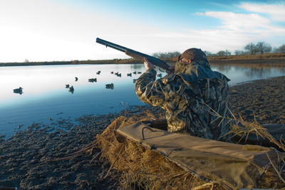 Hunter shooting from layout blind