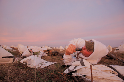 goose hunter using a call in rag spread