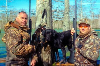 duck hunters in timber camo with dog and duck harvest