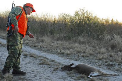 hunter looking at downed deer