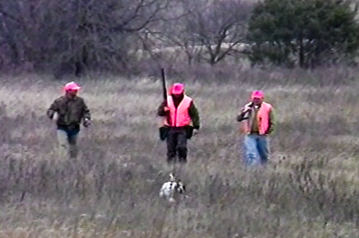 hunters in field with dog