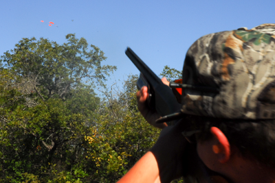 Young shooter aiming at clays