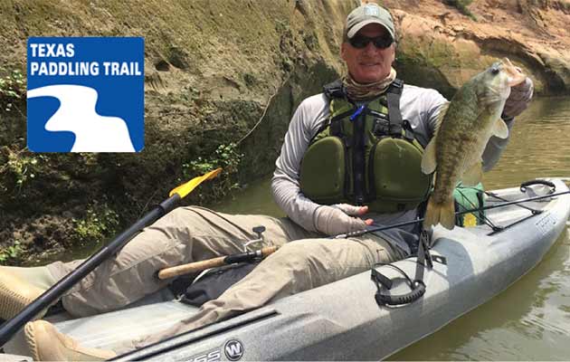 angler on kayak with bass