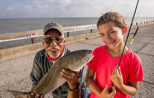 grand father and grand daughter anglers posing with Catfish
