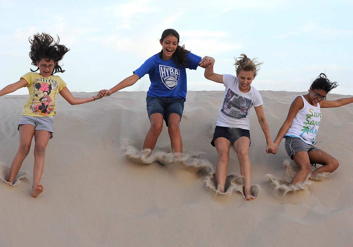 Girl playing in South Padre sand dunes