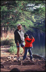 Image of a young boy fishing with his father at Garner State Park