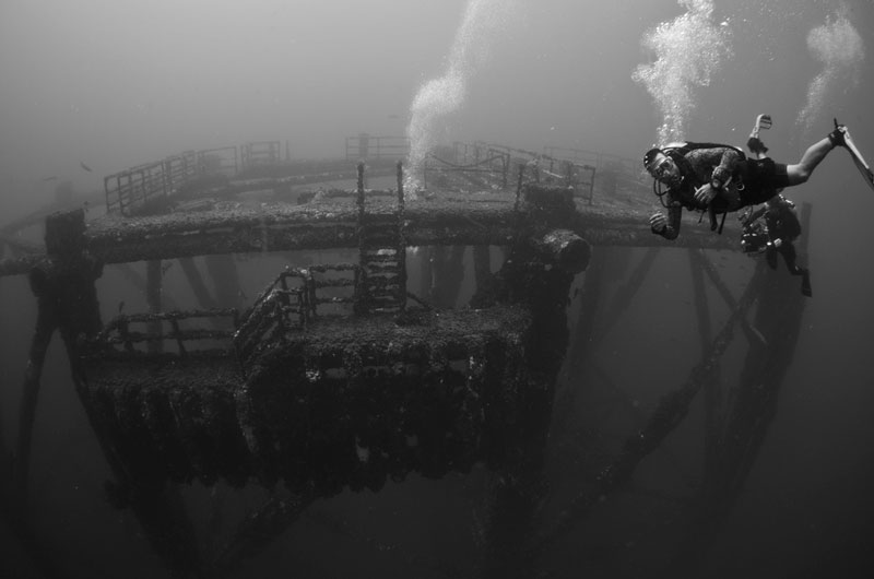 Divers monitor the top of a standing four-pile jacket.