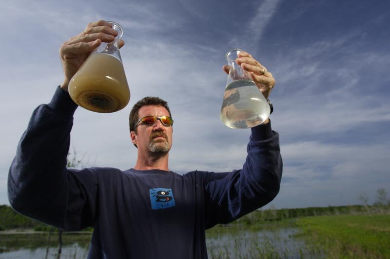Water treatment worker holding two flasks of water, an image of Working and Careers in Water and Aquatic Science from the book Texas Aquatic Science by author Rudolph Rosen.