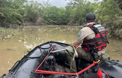 Game Warden on inflatable boat in Texas hill country floodwater