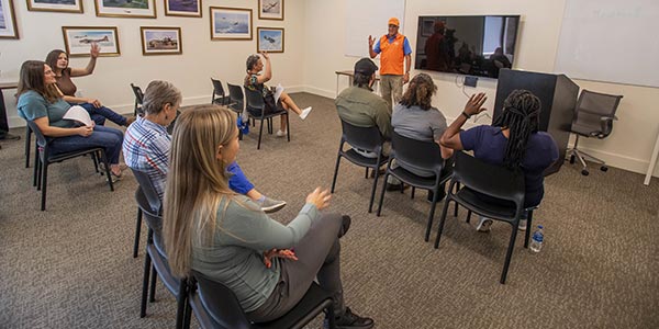 A group of people listening to a firearms safety instructor.