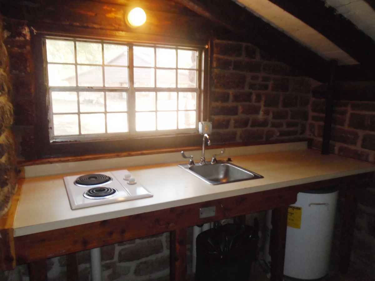 There is a microwave, a small refrigerator, a sink and a 2-burner stove in the kitchen area of Cabin 4.