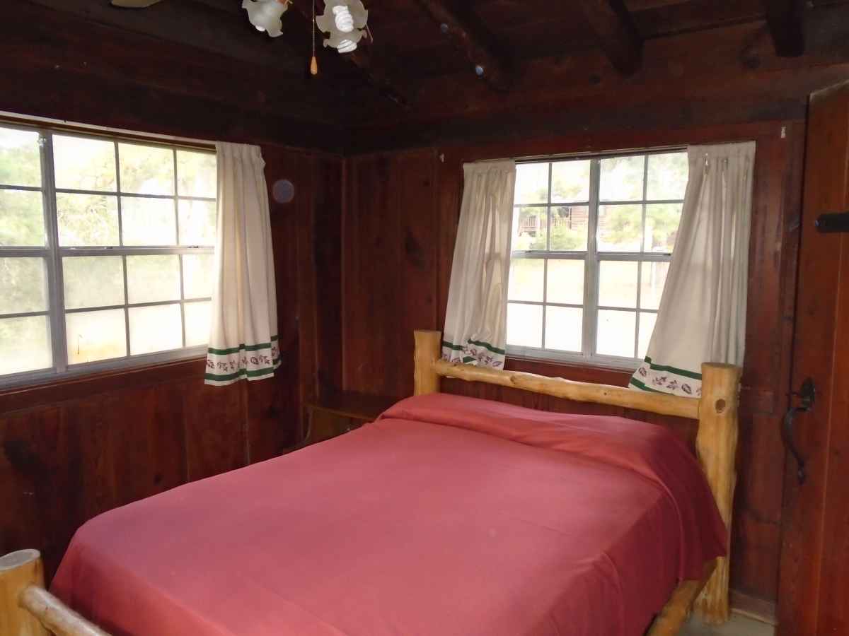 Cabin 8 has a double bed in Bedroom 1, a single bed in Bedroom 2 and a double bed in the living area.  