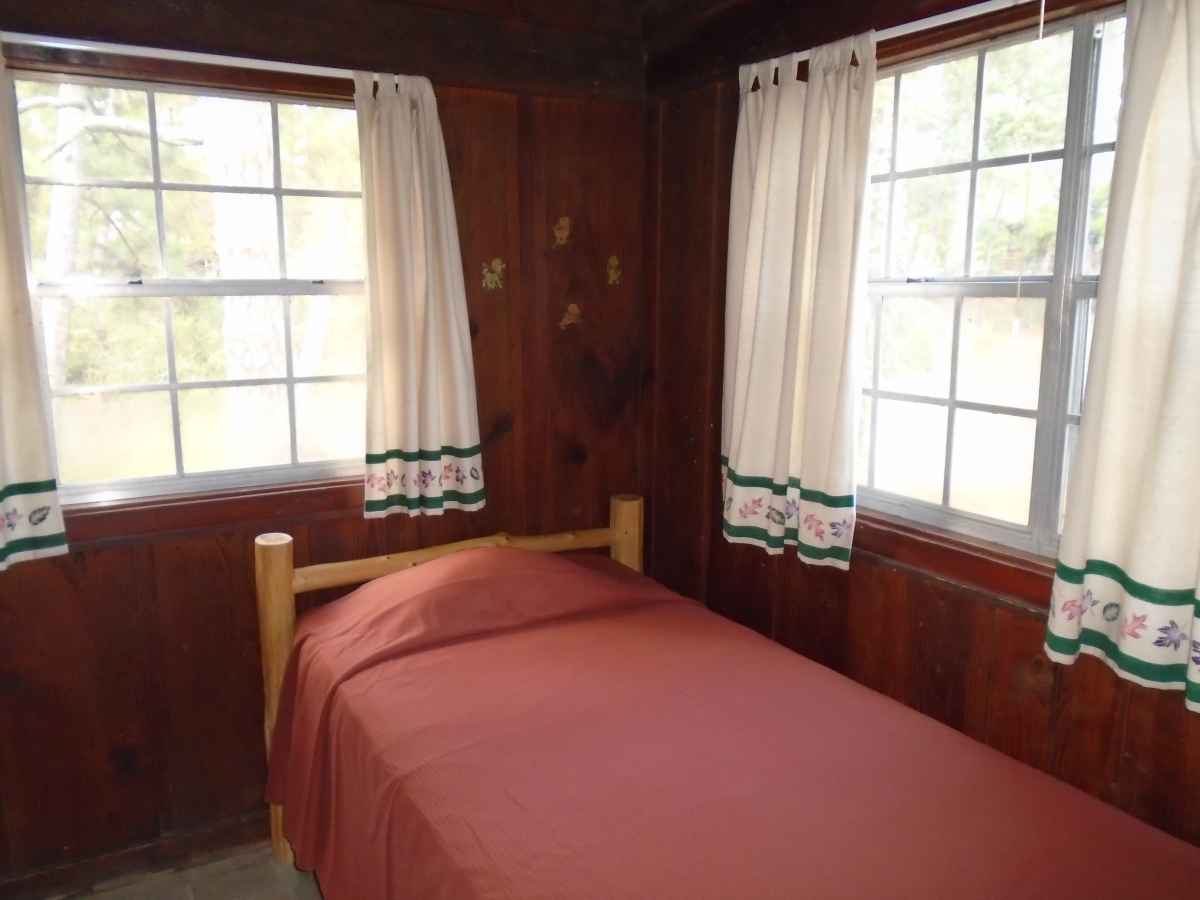 Cabin 8 has a double bed in Bedroom 1, a single bed in Bedroom 2 and a double bed in the living area.  
