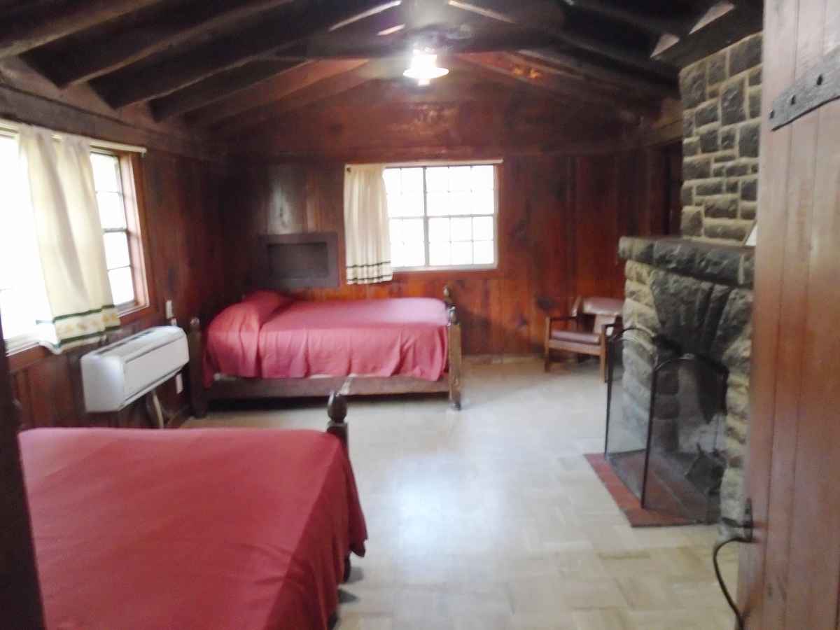 The living area of Cabin 9 has Two double beds and a fireplace.