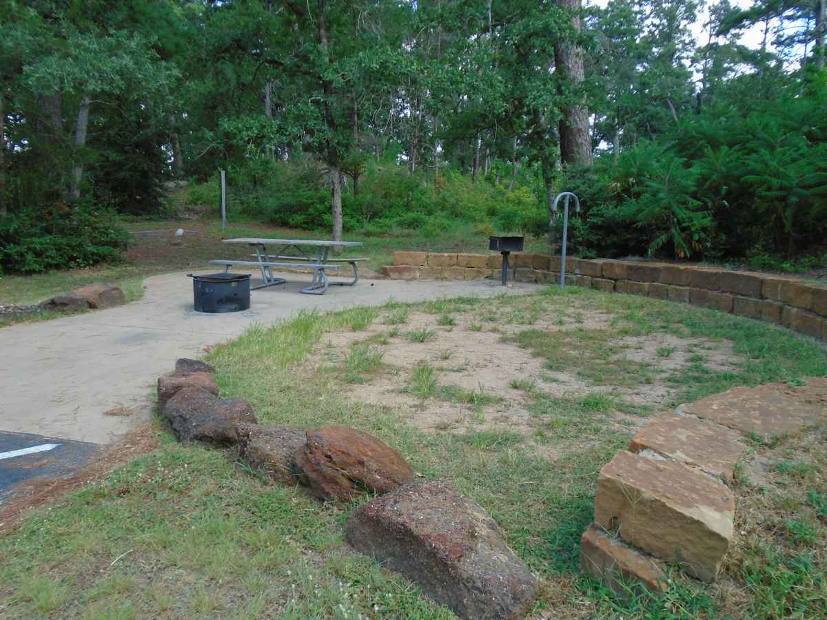 Accessible Campsite #61 has a raised fire ring, upright grill, lantern post, picnic table and paved walkways designed for use with a wheelchair.  