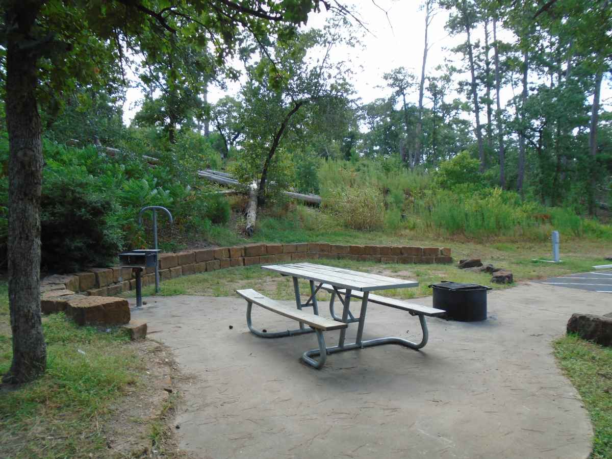 Accessible Campsite #61 has a raised fire ring, upright grill, lantern post, picnic table and paved walkways designed for use with a wheelchair.  