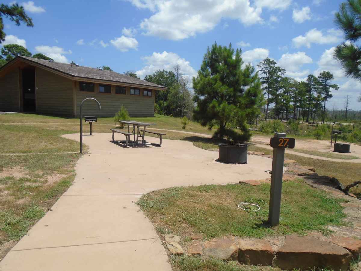 Accessible Campsite #27 is close to the bathrooms and has a raised fire ring, upright grill, lantern post, picnic table and paved walkways designed for use with a wheelchair.  