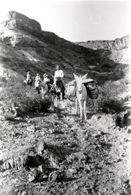 historic image of people riding on horses in the desert