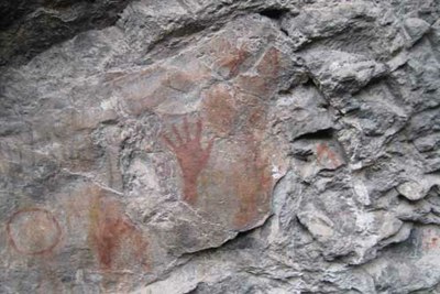 red hand prints on a rock face