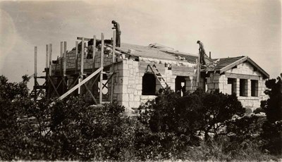 Men standing on roof of building under conostruction