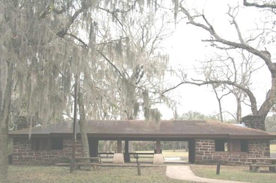 stone pavilion surrounded by trees draped in Spanish moss