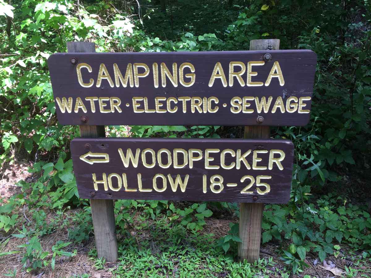 The sign for the Woodpecker Hollow Camping Area, full hookup campsites.