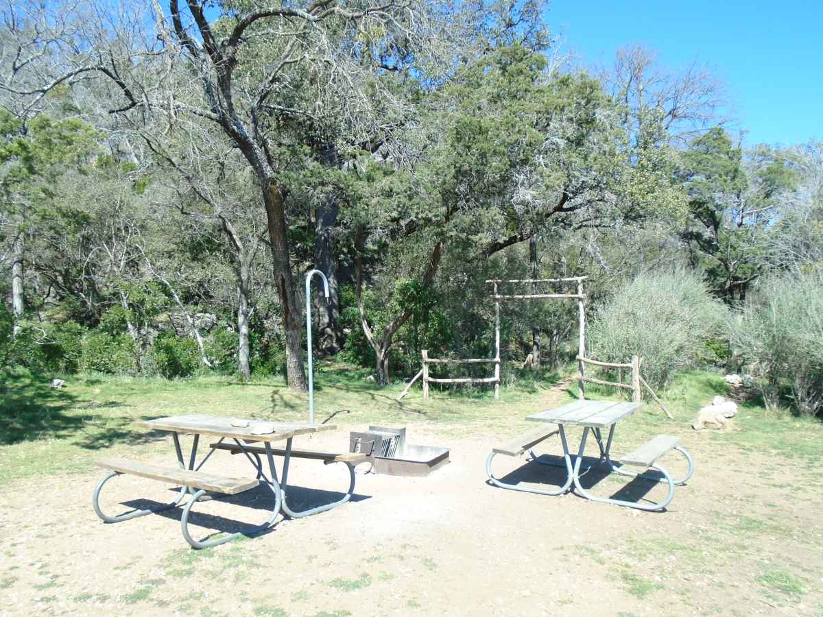 There are three picnic tables, a fire ring and a lantern post.   