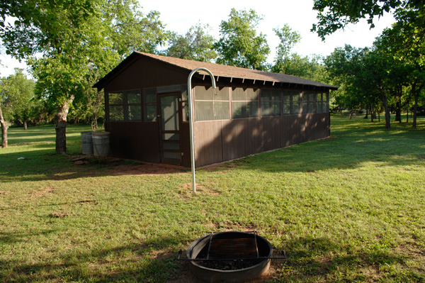 Outside the screened Picnic Pavilion is a fire-ring, trash cans, and a lantern holder.  