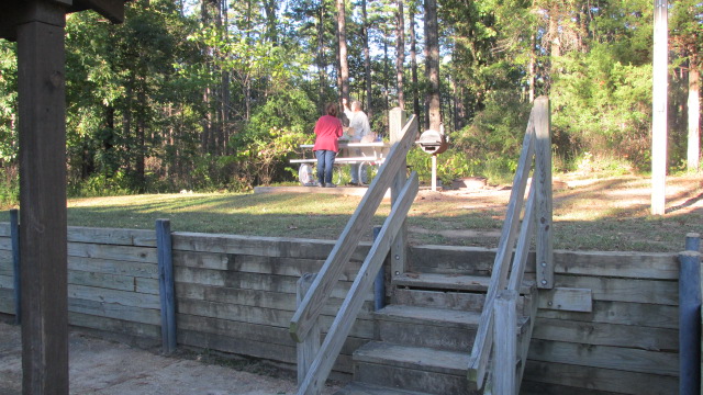 Picnic table and grill behind cabin.