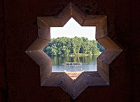View of lake through eight-pointed star in wall of combination buildin