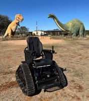 trackchair parked in front of dinosaur models
