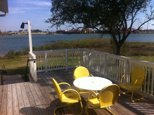 The deck has a table, chairs, light, and a great view of the lake.  