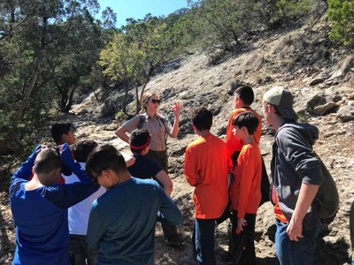 Group of boys listening to a ranger while outdoors in the park