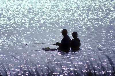 Two anglers wading in waist-high water