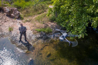 Drone flying above an officer holding its controller
