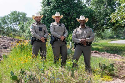 Diverse group of state park police officers posing in nature at Inks Lake State Park