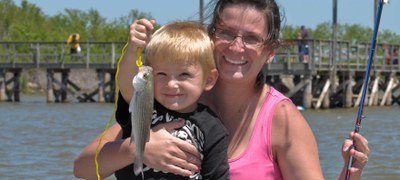 Catching a fish at Lake Livingston with the park's wheelchair accessible fishing pier in the background. 